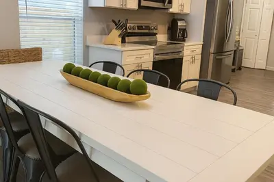 a kitchen table with a bowl of apples on it at Disney-Area 4BR | Pool + Patio in Kissimmee