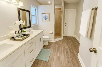 a white bathroom with a shower and a toilet at Disney-Area 4BR | Pool + Patio in Kissimmee