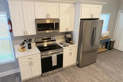 a kitchen with white cabinets and a stainless steel refrigerator at Disney-Area 4BR | Pool + Patio in Kissimmee