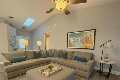 a living room with a couch and a ceiling fan at Disney-Area 4BR | Pool + Patio in Kissimmee