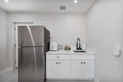 a kitchen with a stainless steel refrigerator and white cabinets at Pet Friendly Studio Unit Near Downtown and Parks - 20 mi to Disney in Saint Cloud