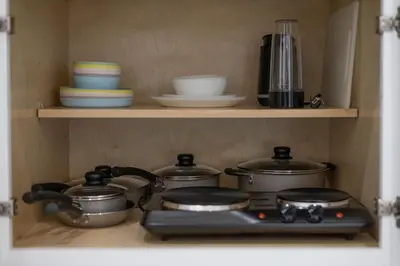 a kitchen stove with pots and pans on a shelf at Pet Friendly Studio Unit Near Downtown and Parks - 20 mi to Disney in Saint Cloud