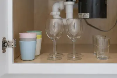 three wine glasses sitting on a shelf with cups at Pet Friendly Studio Unit Near Downtown and Parks - 20 mi to Disney in Saint Cloud