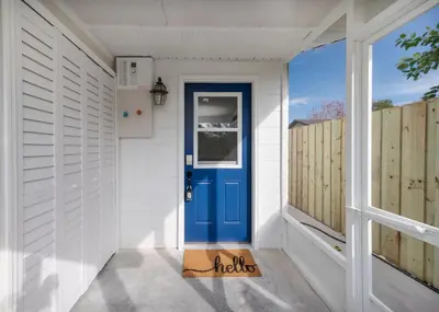 a blue door on a white house with a window at Pet Friendly Studio Unit Near Downtown and Parks - 20 mi to Disney in Saint Cloud