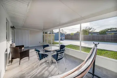 a porch with a hammock and a table and chairs at Downtown Home with Basketball, Firepit and Just 20 Miles to Disney in Saint Cloud