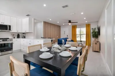 a kitchen and dining room with a table and chairs at Downtown Home with Basketball, Firepit and Just 20 Miles to Disney in Saint Cloud