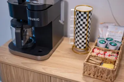 a coffee maker sitting on top of a wooden counter with a box of coffee at 10 Minutes to Downtown with Jacuzzi, Pool Table, Ping Pong, and BBQ in Orlando