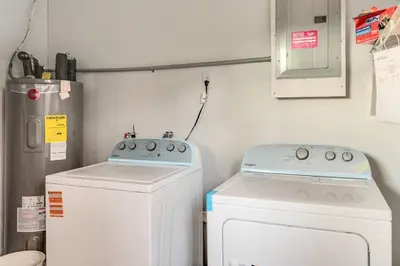 a laundry room with a stove and a washer at 10 Minutes to Downtown with Jacuzzi, Pool Table, Ping Pong, and BBQ in Orlando