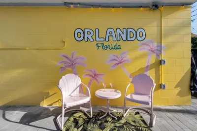 two chairs and a table in front of a yellow wall at Cozy Orlando Studio with Jacuzzi, Fire Pit, and BBQ in Orlando