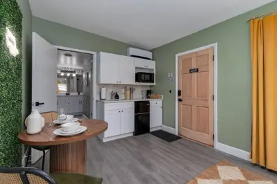 a kitchen with a small table and a kitchen with white cabinets at Cozy Orlando Studio with Jacuzzi, Fire Pit, and BBQ in Orlando