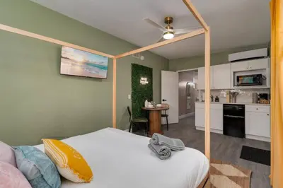 a bedroom with a bed and a kitchen at Cozy Orlando Studio with Jacuzzi, Fire Pit, and BBQ in Orlando