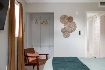 a bedroom with a bed and a chair next to a window at Stylish 2BR Home Near Disney and Universal Orlando in Orlando