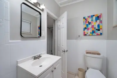 a white bathroom with a sink and a mirror at Stylish 2BR Home Near Disney and Universal Orlando in Orlando