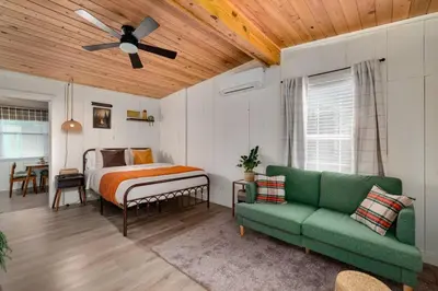 a bedroom with a bed and a green couch at Modern Downtown Orlando Studio in a Prime Location in Orlando
