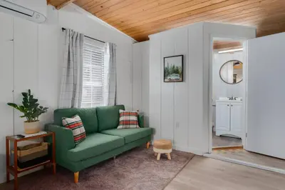 a living room with a green couch and a table at Modern Downtown Orlando Studio in a Prime Location in Orlando