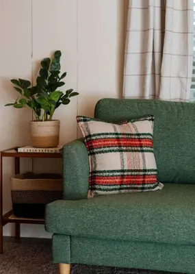 a green chair with a pillow next to a plant at Modern Downtown Orlando Studio in a Prime Location in Orlando