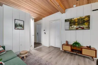 a living room with a green couch and a wooden ceiling at Modern Downtown Orlando Studio in a Prime Location in Orlando