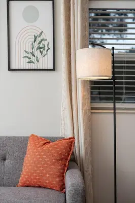 a living room with a couch and a lamp and a window at Chic Studio Near Downtown & Theme Parks in Orlando