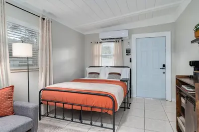 a bedroom with a bed and a chair and a window at Chic Studio Near Downtown & Theme Parks in Orlando