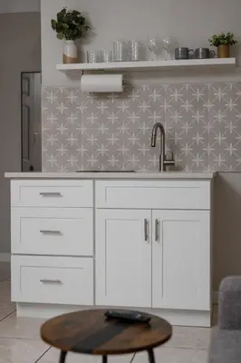 a white kitchen with a sink and a table at Chic Studio Near Downtown & Theme Parks in Orlando