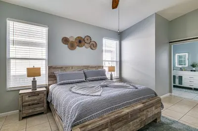 a bedroom with a bed and two windows at Resort Perks! Family Home 4 Mi to Disney World in Kissimmee
