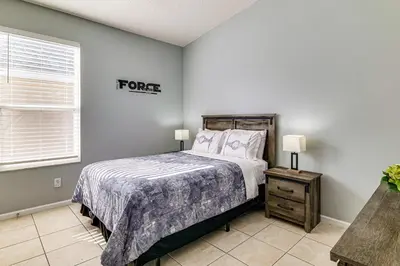 a bedroom with a bed and a sign on the wall at Resort Perks! Family Home 4 Mi to Disney World in Kissimmee