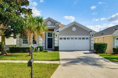 a house with a palm tree and a driveway at Resort Perks! Family Home 4 Mi to Disney World in Kissimmee