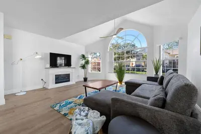 a living room with a couch and a fireplace at Bright Ground Floor Condo Minutes to Parks in Kissimmee