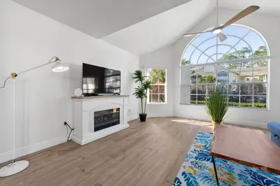 a living room with white walls and a fireplace at Bright Ground Floor Condo Minutes to Parks in Kissimmee