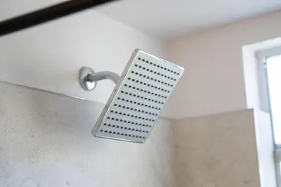 a shower head hanging from a wall in a bathroom at Bright Ground Floor Condo Minutes to Parks in Kissimmee