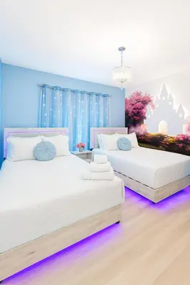 two beds in a room with purple lights at NEW Luxury 7BR Villa 4 Mi to Disney Pool & Spa in Kissimmee