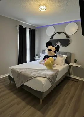 a stuffed animal sitting on a bed in a bedroom at NEW Luxury 7BR Villa 4 Mi to Disney Pool & Spa in Kissimmee