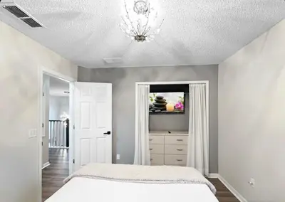 a bedroom with a bed and a chandelier at NEW Luxury 7BR Villa 4 Mi to Disney Pool & Spa in Kissimmee
