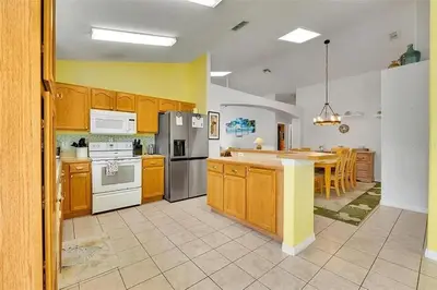 a large kitchen with wooden cabinets and a kitchen island at 5BR 4BA Near Disney, Pool, Sauna, Pets Allowed in Kissimmee