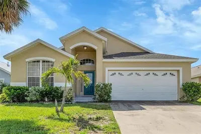 a house with a garage and a palm tree at 5BR 4BA Near Disney, Pool, Sauna, Pets Allowed in Kissimmee