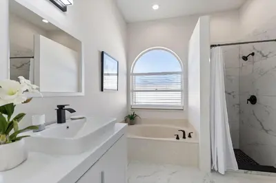 a white bathroom with a tub and a sink at Magical Hideaway at Kissimmee by Shine Villas villa in Kissimmee