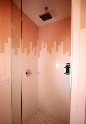 a shower in a bathroom with orange and white tiles at Suites by The Wellborn in Orlando