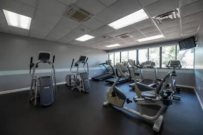 a gym with several tread machines in a room at Condo with Pool, Gym, Golf, Jacuzzi and Game Areas in Orlando