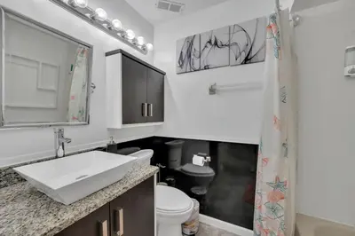 a white bathroom with a sink and a toilet at Cozy Golf Condo with 3 Pools, Gym and Just 15 Minutes to Airport in Orlando