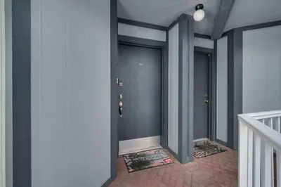 a hallway with three blue doors and a staircase at Cozy Golf Condo with 3 Pools, Gym and Just 15 Minutes to Airport in Orlando
