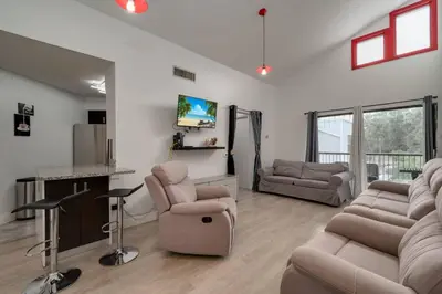 a living room with a couch and chairs and a tv at Cozy Golf Condo with 3 Pools, Gym and Just 15 Minutes to Airport in Orlando