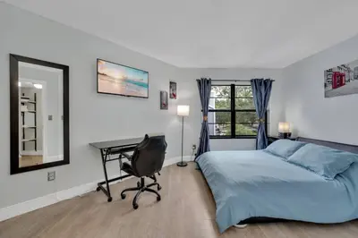 a bedroom with a bed and a desk and a window at Cozy Golf Condo with 3 Pools, Gym and Just 15 Minutes to Airport in Orlando