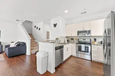 a kitchen with white cabinets and stainless steel appliances at 8925 Resort 4BR Townhouse by Disney World Orlando in Kissimmee