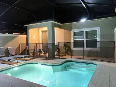 a large swimming pool with chairs and a table at 4263PD-New Listing- 5 bed/4 bath-Private Pool in Kissimmee