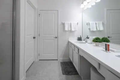 a white bathroom with two sinks and a mirror at 2026 NEW Home 8 Bedrooms At Bella Vida in Kissimmee