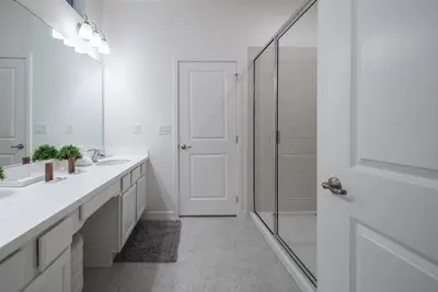 a white bathroom with two sinks and a shower at 2026 NEW Home 8 Bedrooms At Bella Vida in Kissimmee