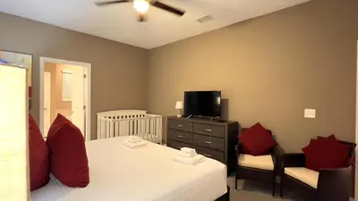 a bedroom with a bed with red pillows and a tv at 4573TB-New Listing- 10bed/5 bath-Private Pool in Kissimmee