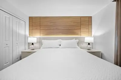 a bedroom with a large white bed with two lamps at Brand NEW Home 09 BedroomsPoolGame Room in Kissimmee