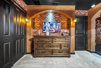 a wooden dresser in a room with a brick wall at Brand NEW Home 09 BedroomsPoolGame Room in Kissimmee