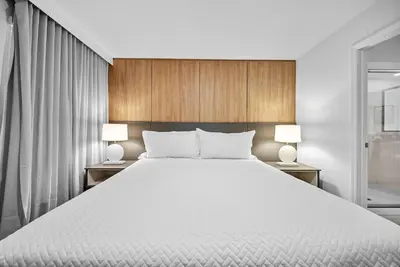 a bedroom with a large white bed with two lamps at Brand NEW Home 09 BedroomsPoolGame Room in Kissimmee